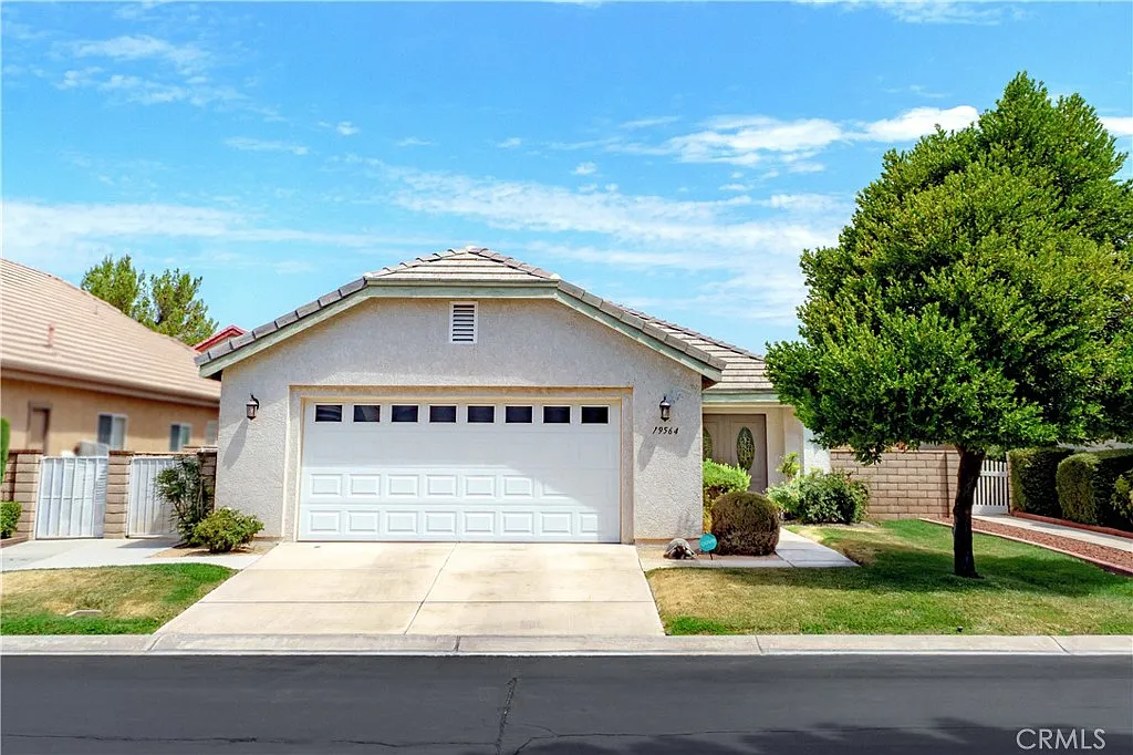 Front garage and tree and well-maintained lawn in California